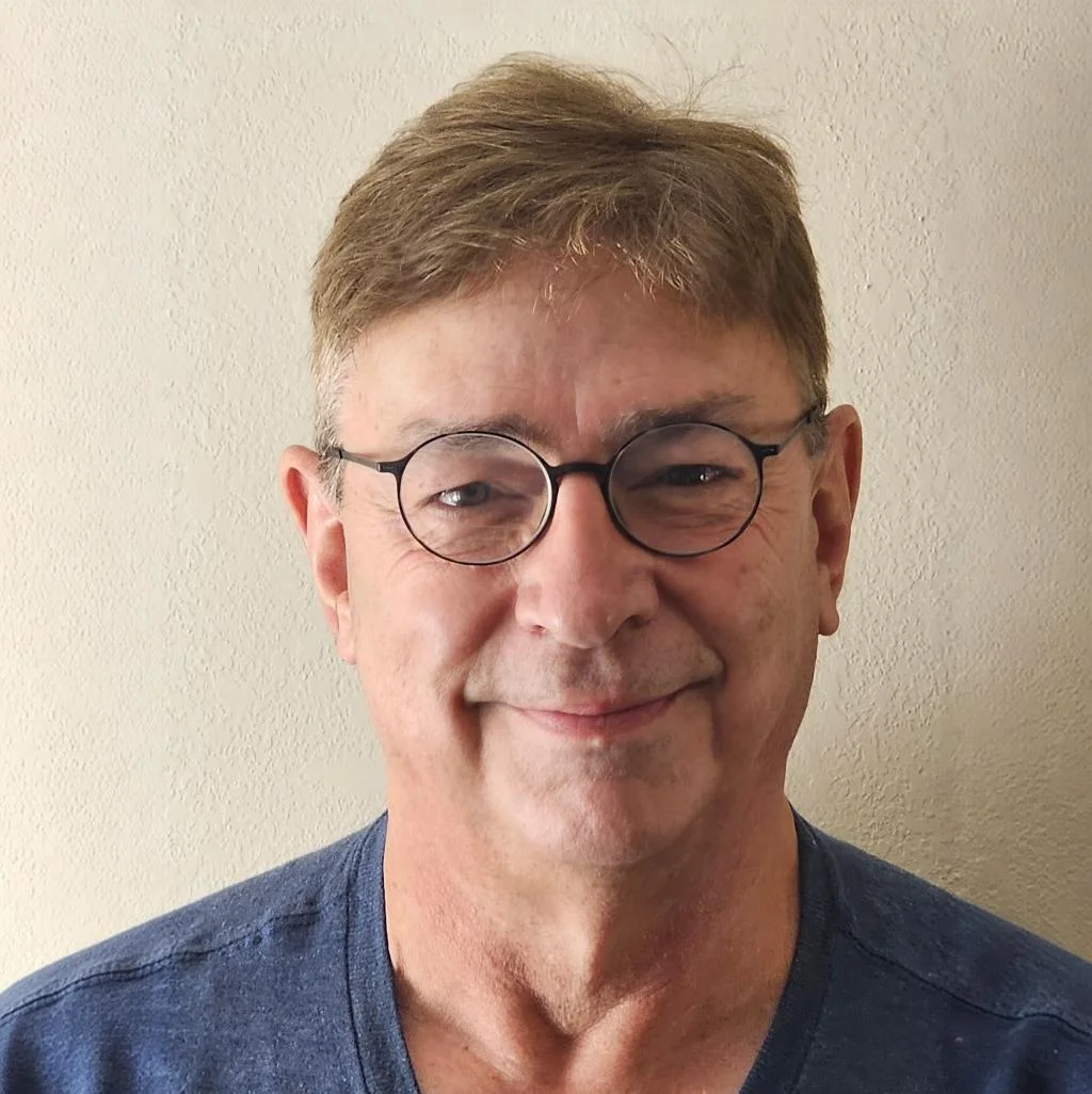 Portrait of Dr. Gaddis wearing round glasses and smiling.